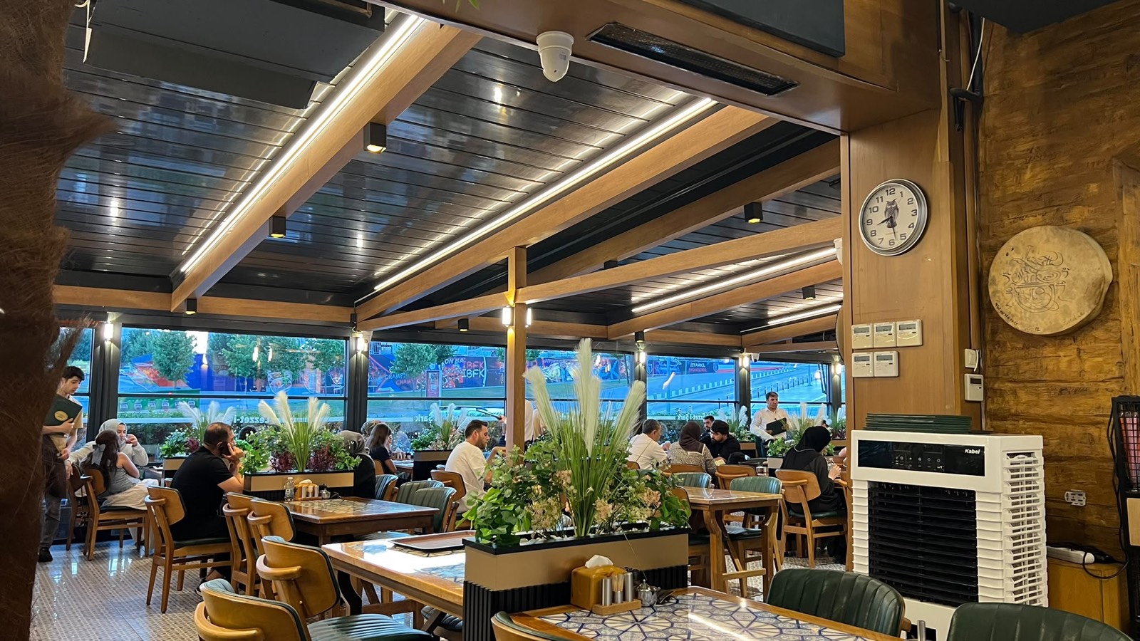 Lezzet-i Şark, Başakşehir: ahşap rolling roof pergola ve giyotin cam cepheli salon · Solarwin